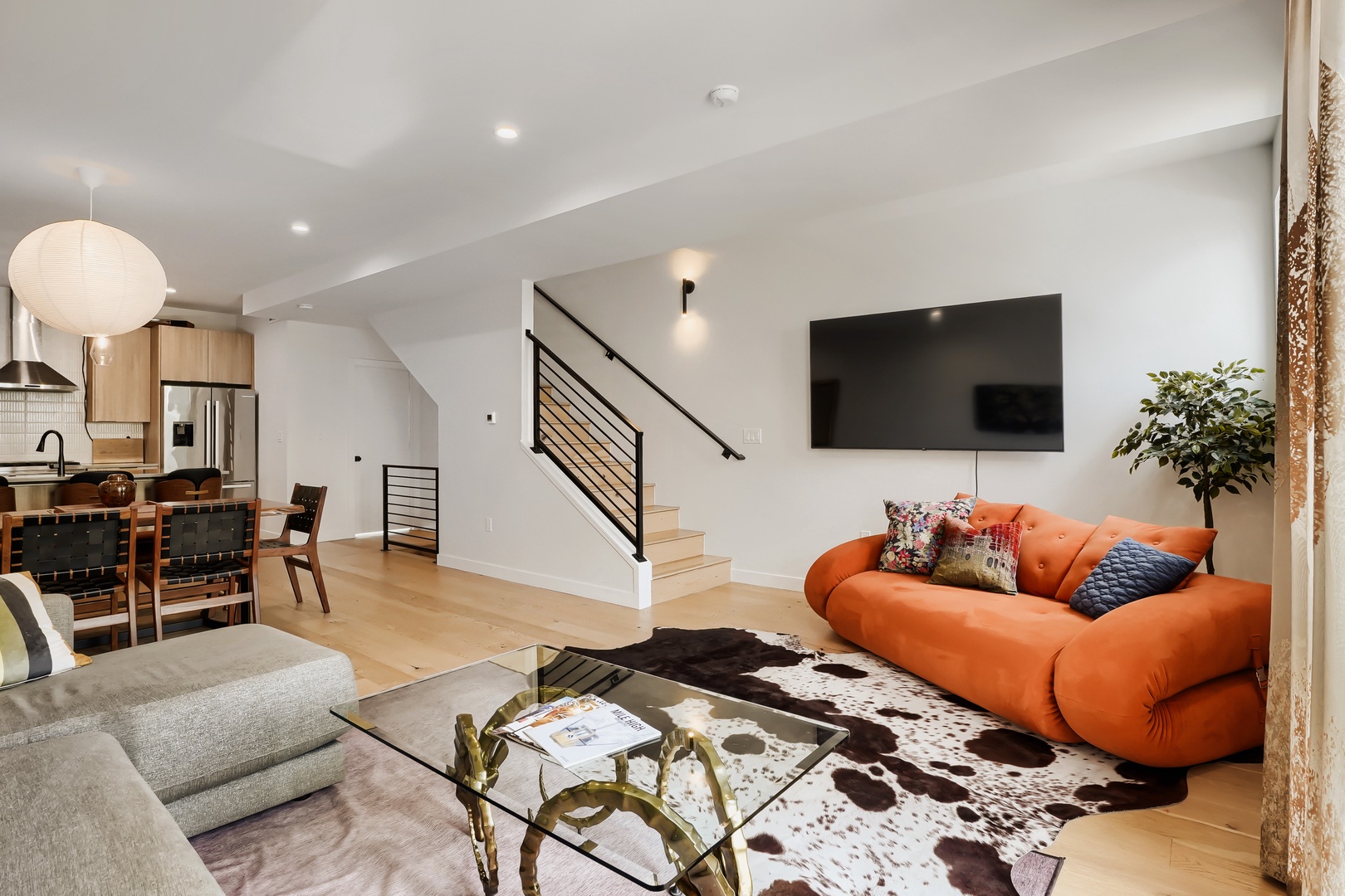 Step into your open-concept retreat where modern design meets warm comfort. Relax on the vibrant sofa in the spacious living area, or gather around the dining table just steps from the well-equipped kitchen—perfect for making memories.