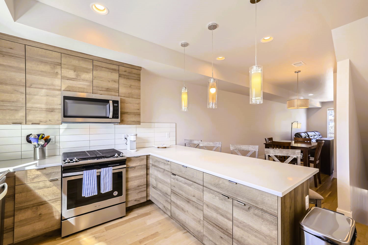 Cook memorable meals in your modern kitchen featuring warm wood cabinetry, gleaming countertops, and pendant lighting creating the perfect culinary atmosphere.