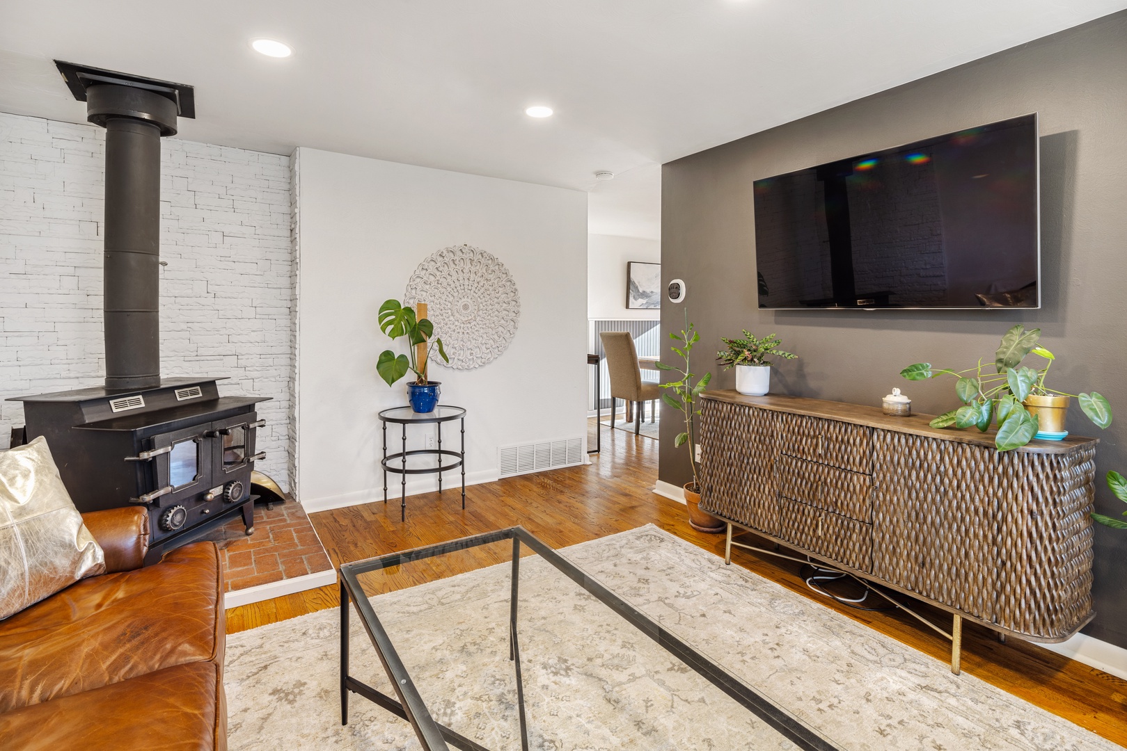 Cozy up by your wood-burning fireplace while watching the big screen TV in this stylish living space with warm wood floors.