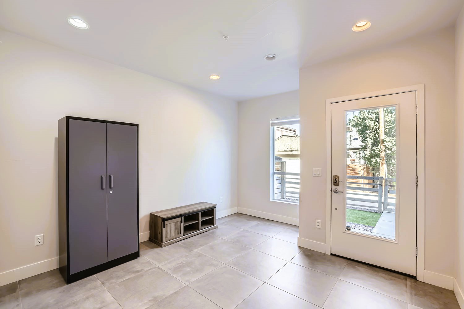Step into your bright, modern entryway with sleek storage and natural light welcoming you home through glass doors.