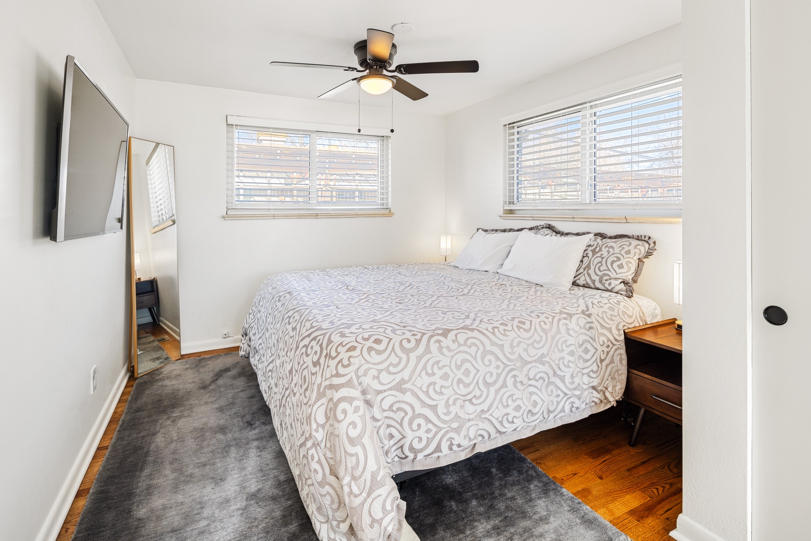 Your peaceful bedroom features a comfortable queen bed with soft linens, natural light, and a ceiling fan for perfect sleep comfort.