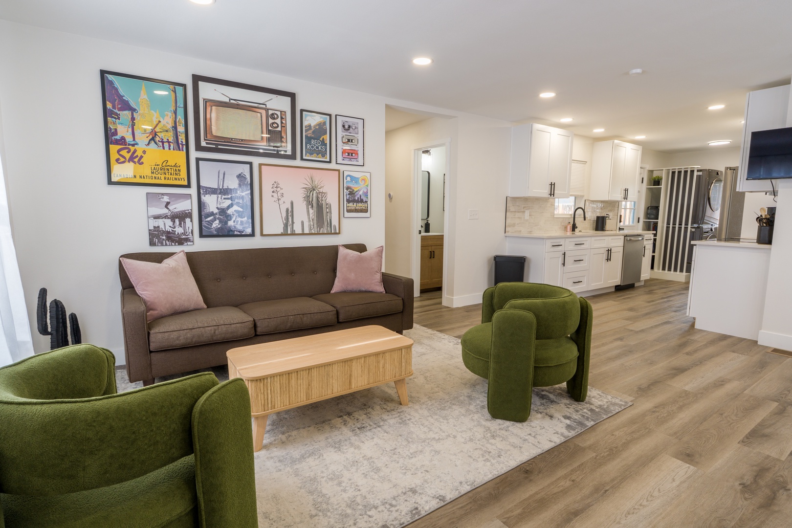 Sink into plush seating while admiring curated artwork in your bright, open-concept retreat with modern kitchen and stylish furnishings.