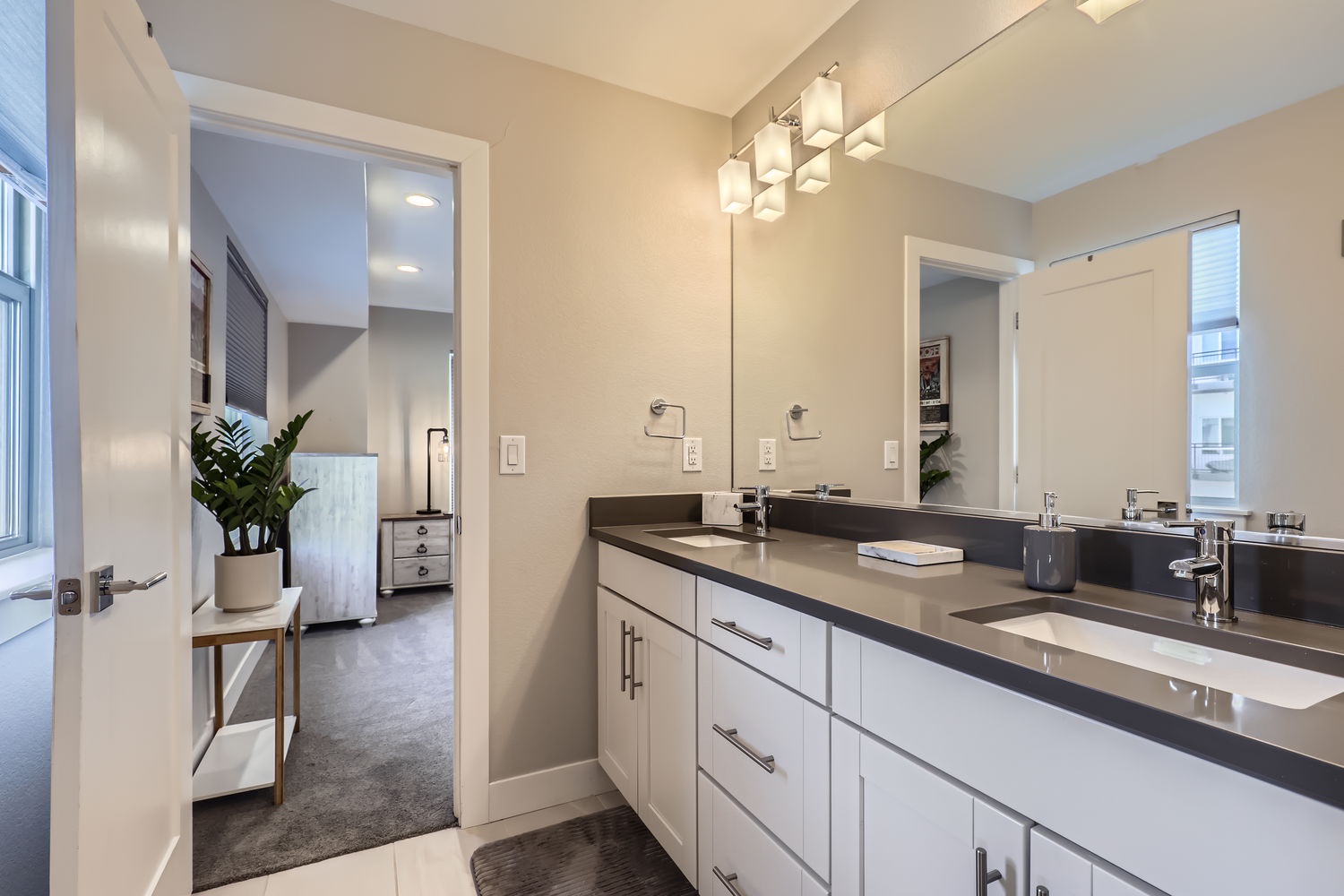 Step into your private spa-like bathroom with a sleek double vanity, modern fixtures, and bright lighting. You'll love the clean lines and ample counter space that make your morning routine effortless.