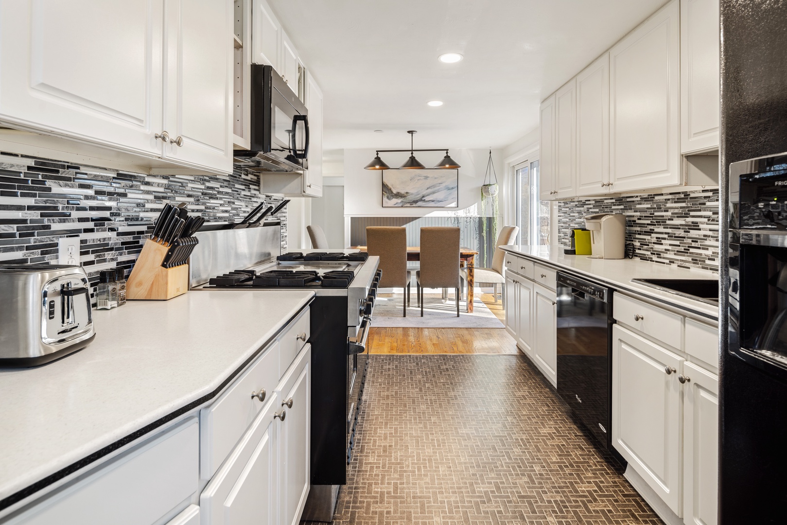 You'll love cooking in this bright, fully-equipped kitchen with modern appliances, elegant counters, and stylish backsplash.