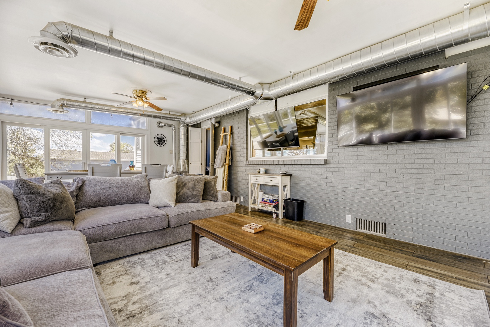 Unwind in your spacious living room with exposed brick, plush seating, and a large flat-screen TV—perfect for movie nights after a day of exploring the area.