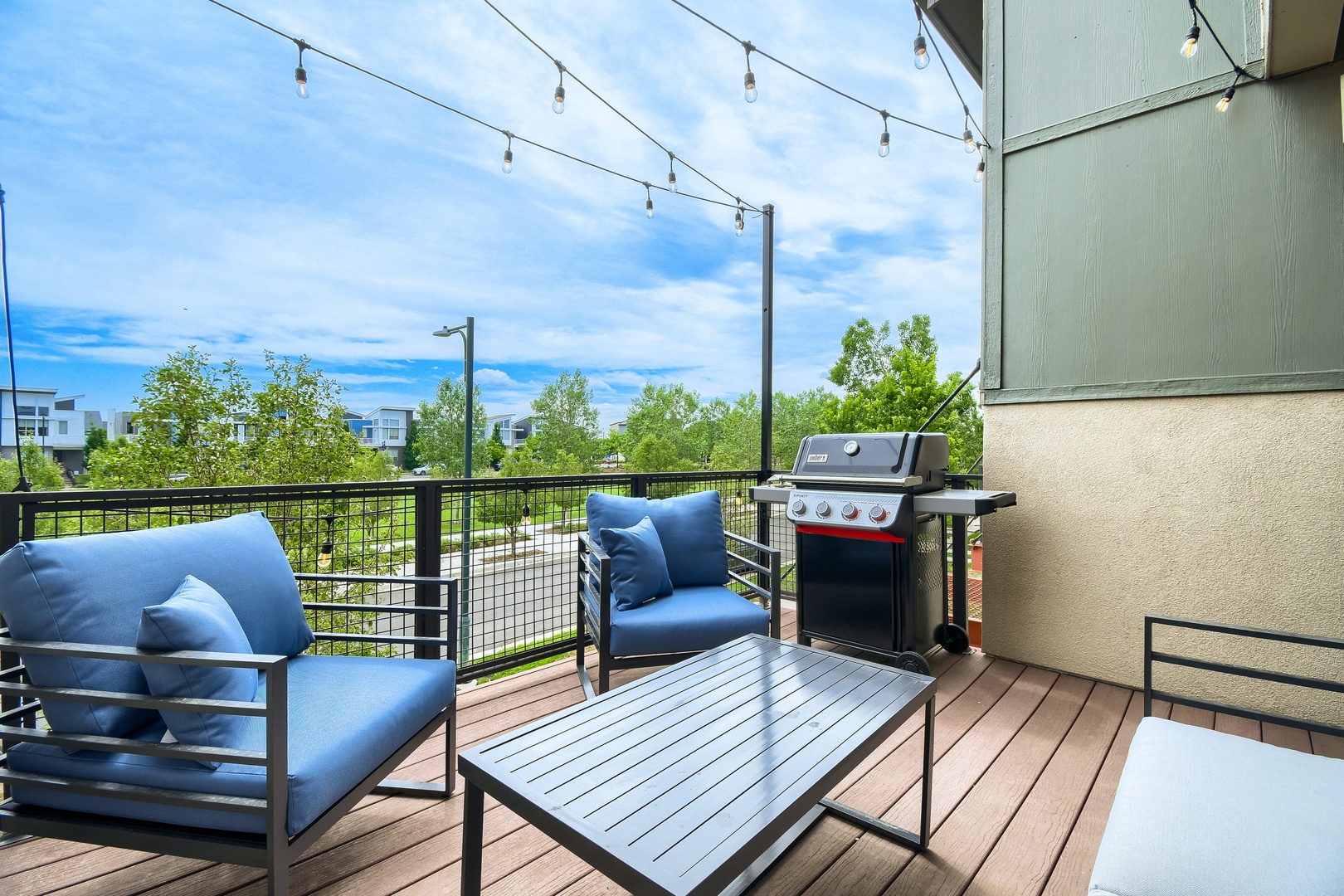 Unwind on your private deck with plush seating and a gas grill, perfect for al fresco dining while enjoying peaceful green views and warm string-lit evenings.