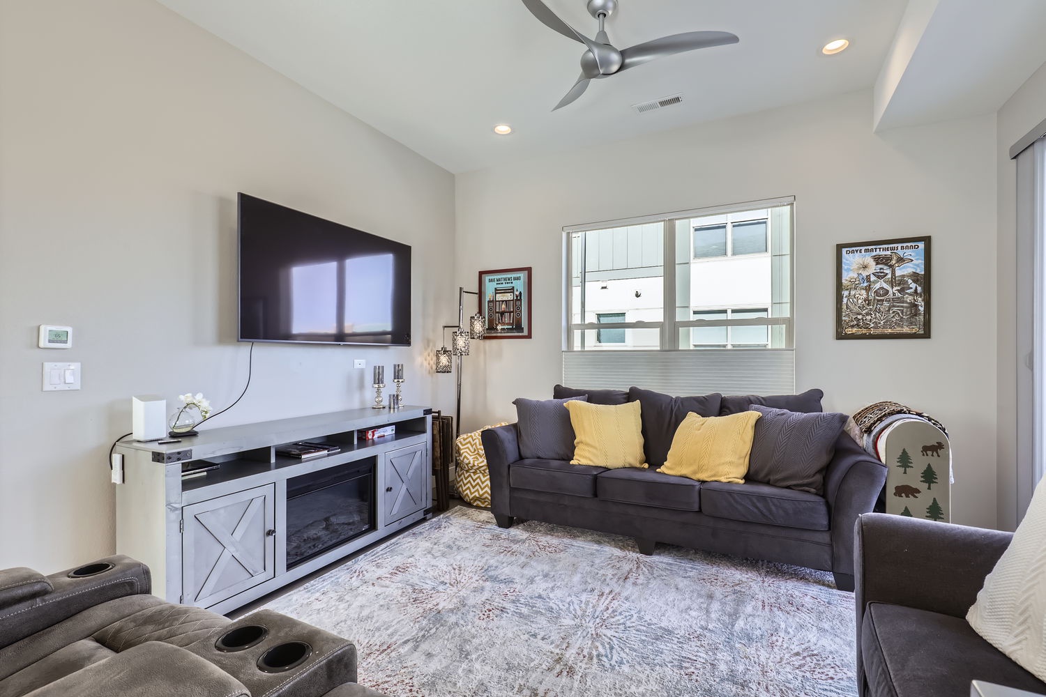 Sink into the plush sofa and unwind in this inviting living space, where natural light flows through the windows and a cozy fireplace awaits your return.