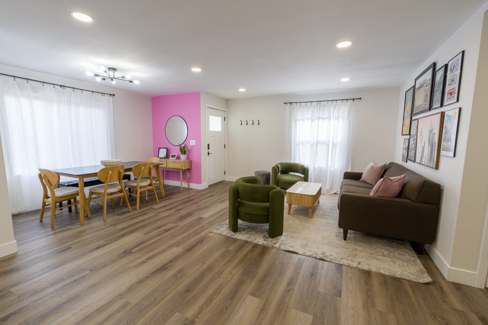 Your open-concept living space blends comfort with style, featuring a cozy sofa, vibrant green chairs, and natural light streaming through white curtains.