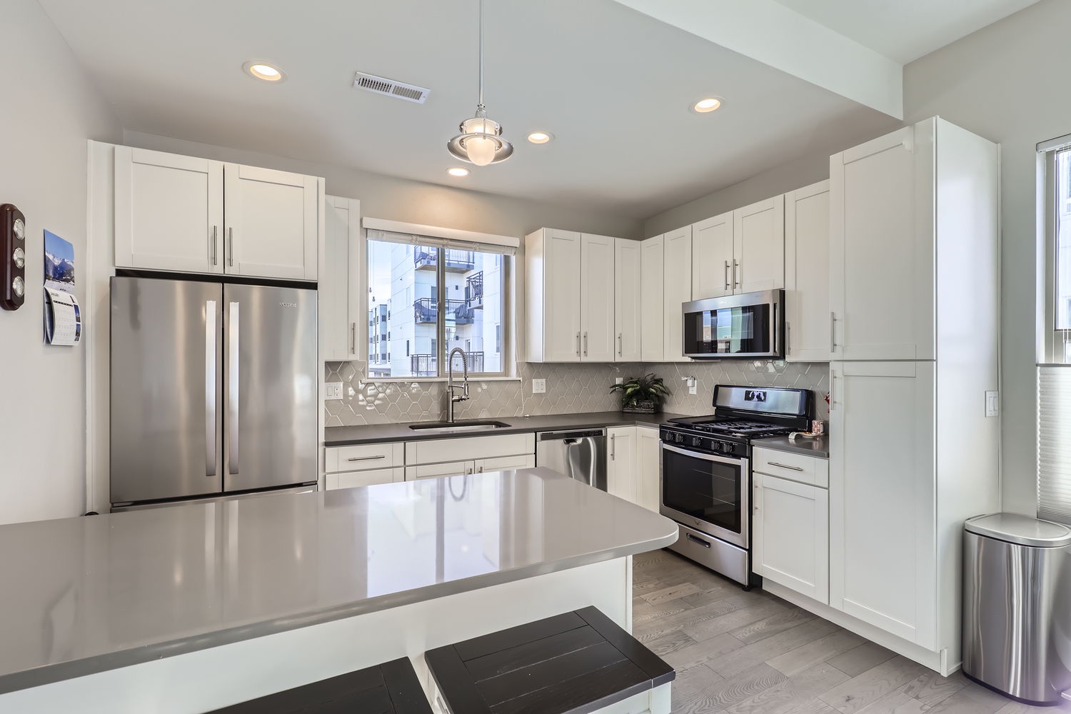Step into your bright, modern kitchen where crisp white cabinetry and stainless steel appliances make meal prep a pleasure, while the spacious island invites you to gather and create.