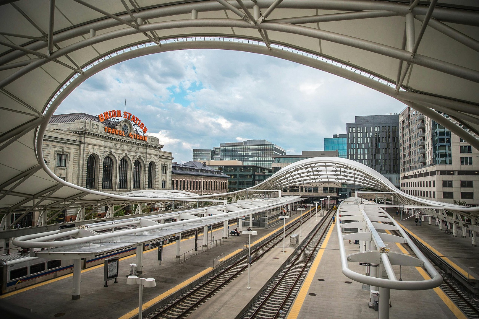 Modern transit station with Union Station's historic architecture and downtown skyline creating an impressive arrival experience.