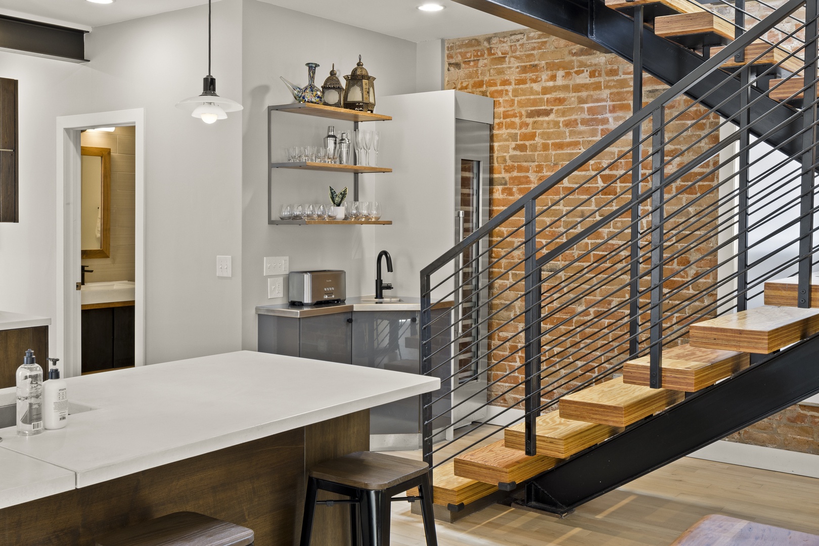 Your modern kitchen blends sleek countertops with warm exposed brick, creating the perfect space for entertaining.