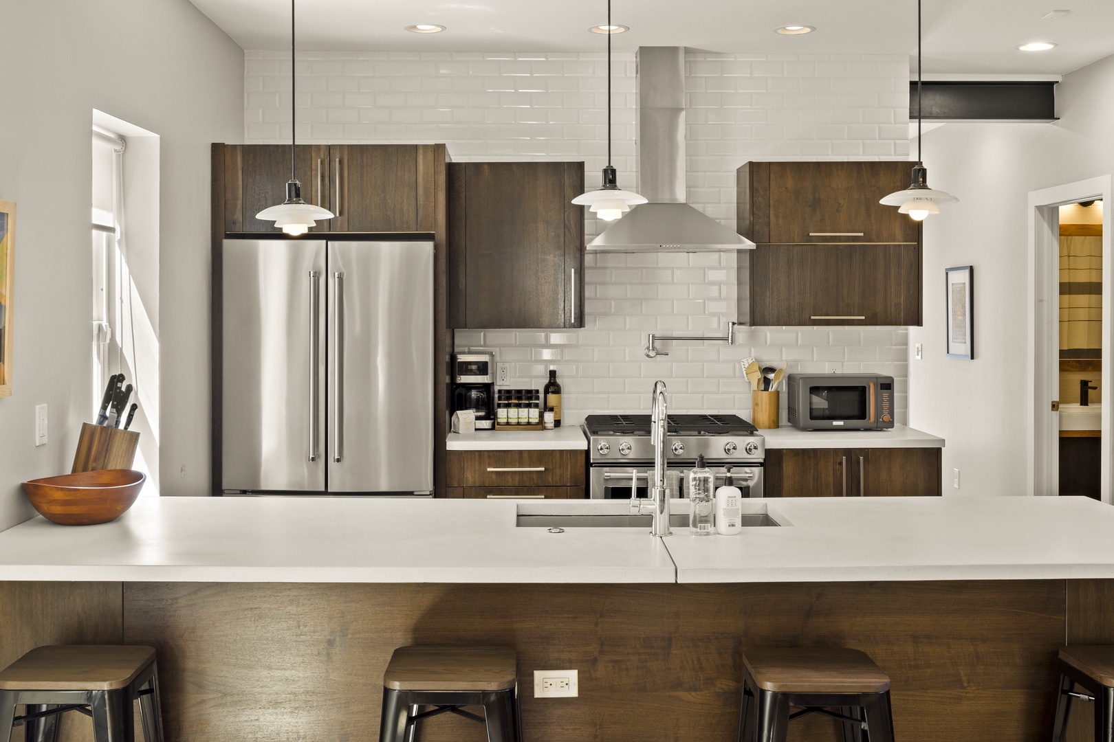 Your modern kitchen awaits with sleek white counters, stainless steel appliances, and warm wood cabinetry perfect for memorable meals.