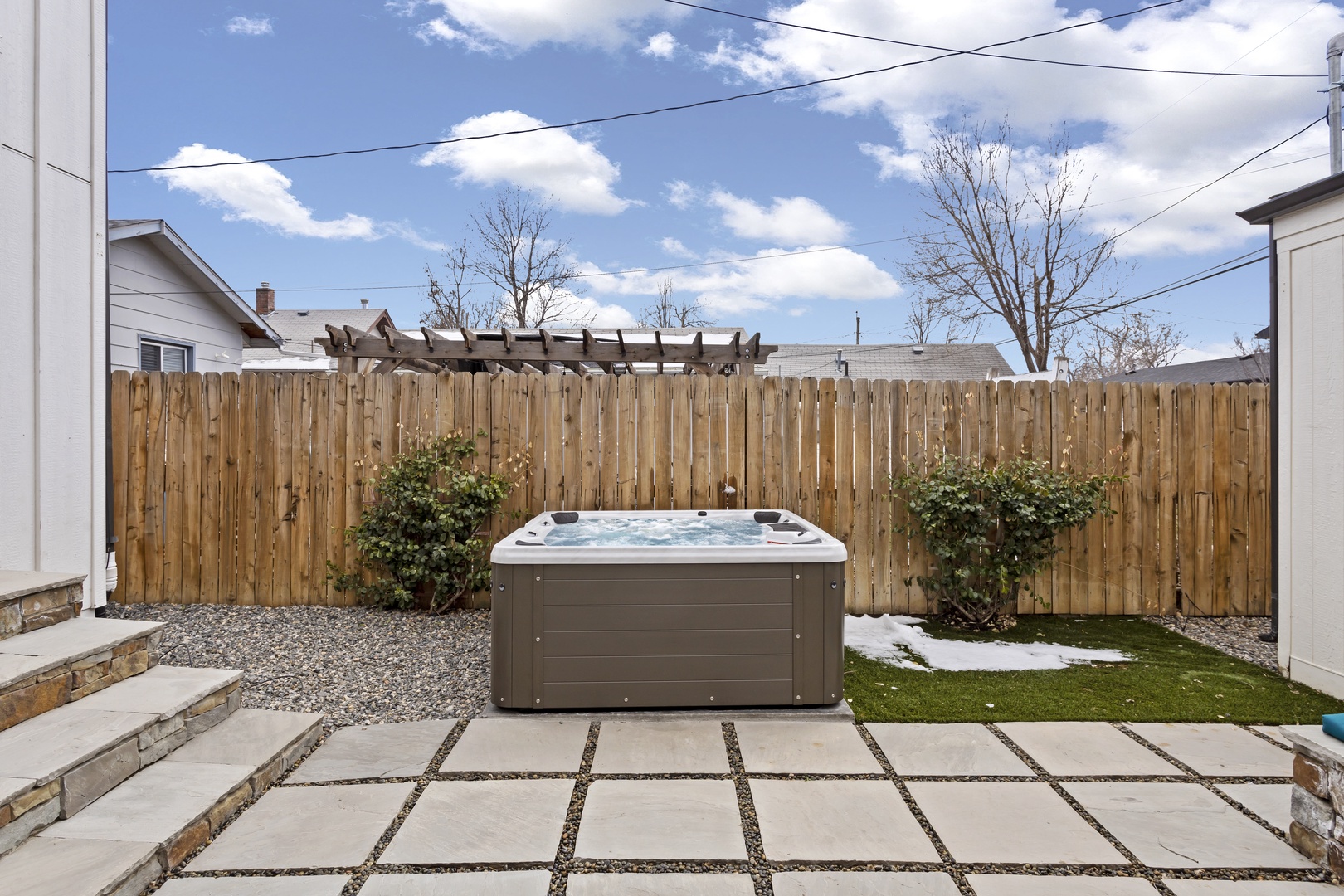 Unwind in your private hot tub surrounded by landscaped gardens and modern patio design—perfect for evening relaxation under the stars.