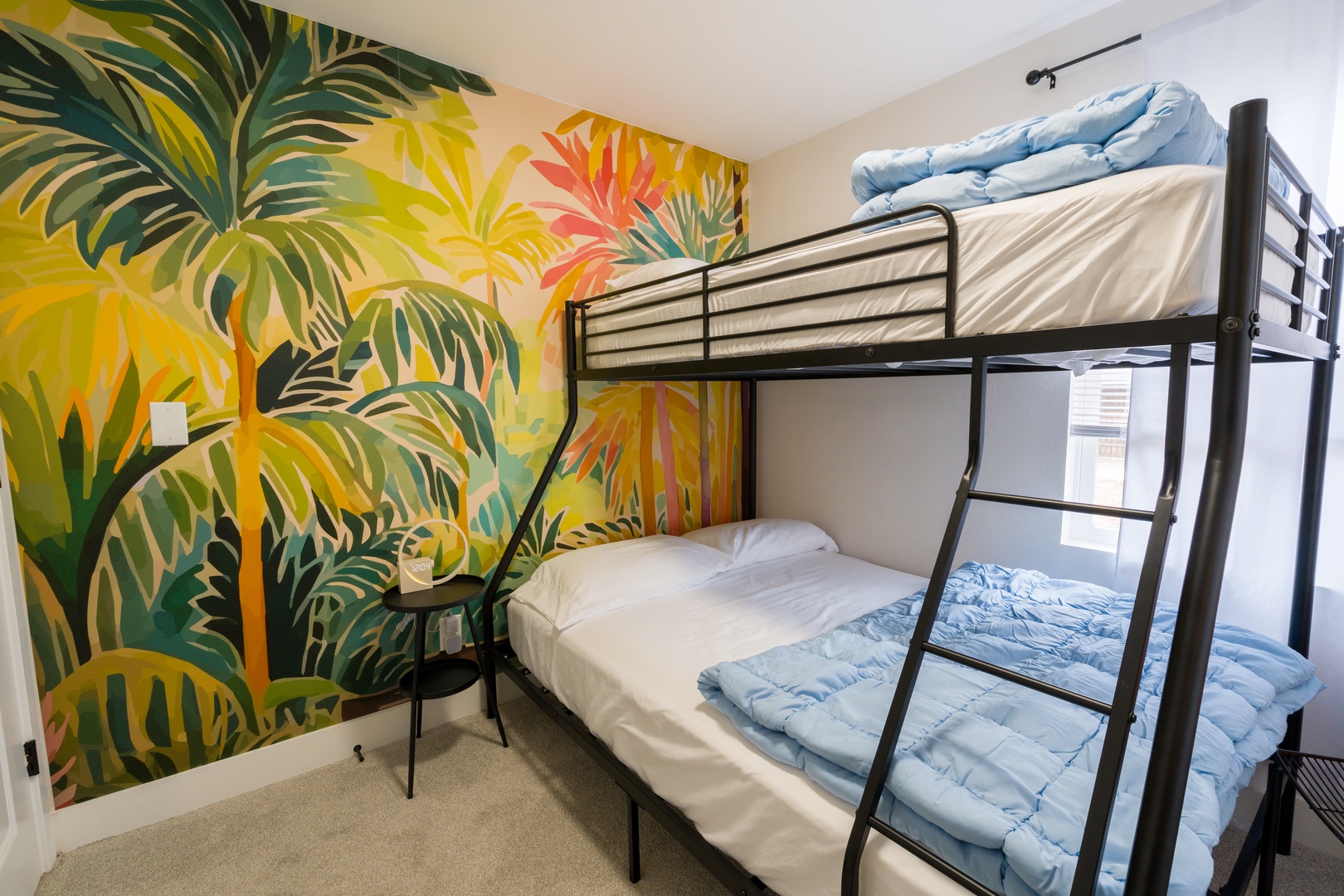 Wake up to tropical vibes in your cozy bunk room, where vibrant palm murals transport you to paradise.