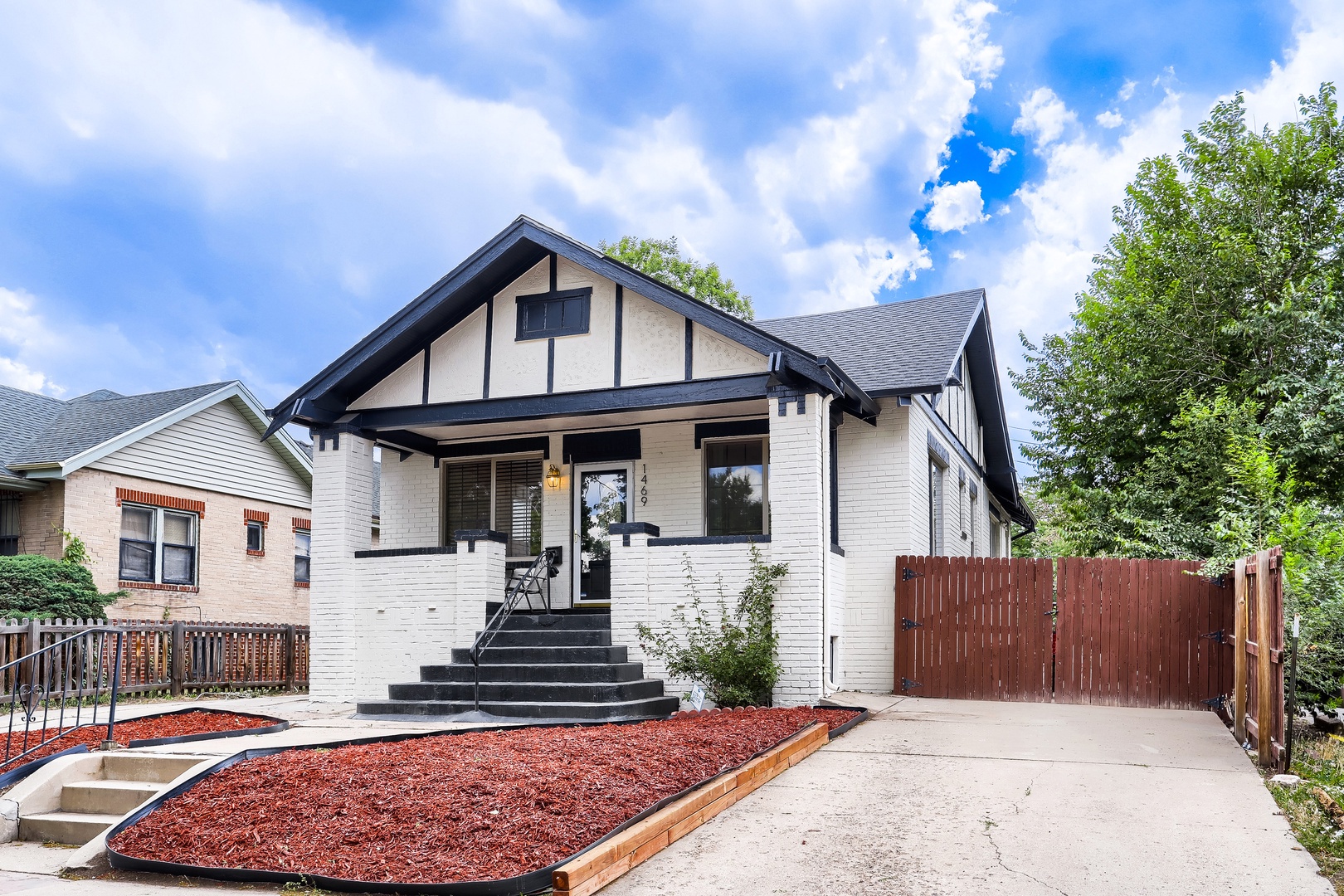 A charming craftsman-style home features a welcoming covered porch, classic black and white exterior, and private fenced backyard in a peaceful residential neighborhood.