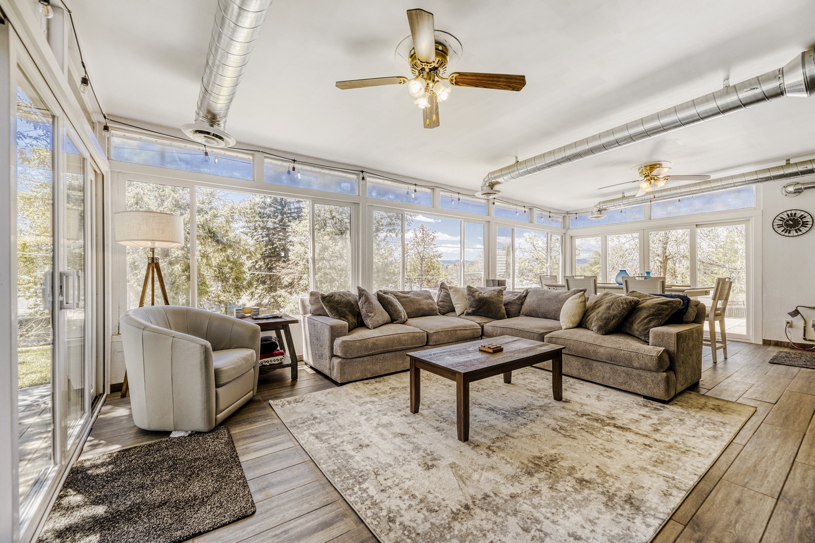 Sink into plush seating surrounded by walls of windows that flood your living space with natural light and peaceful views, creating the perfect spot to unwind.