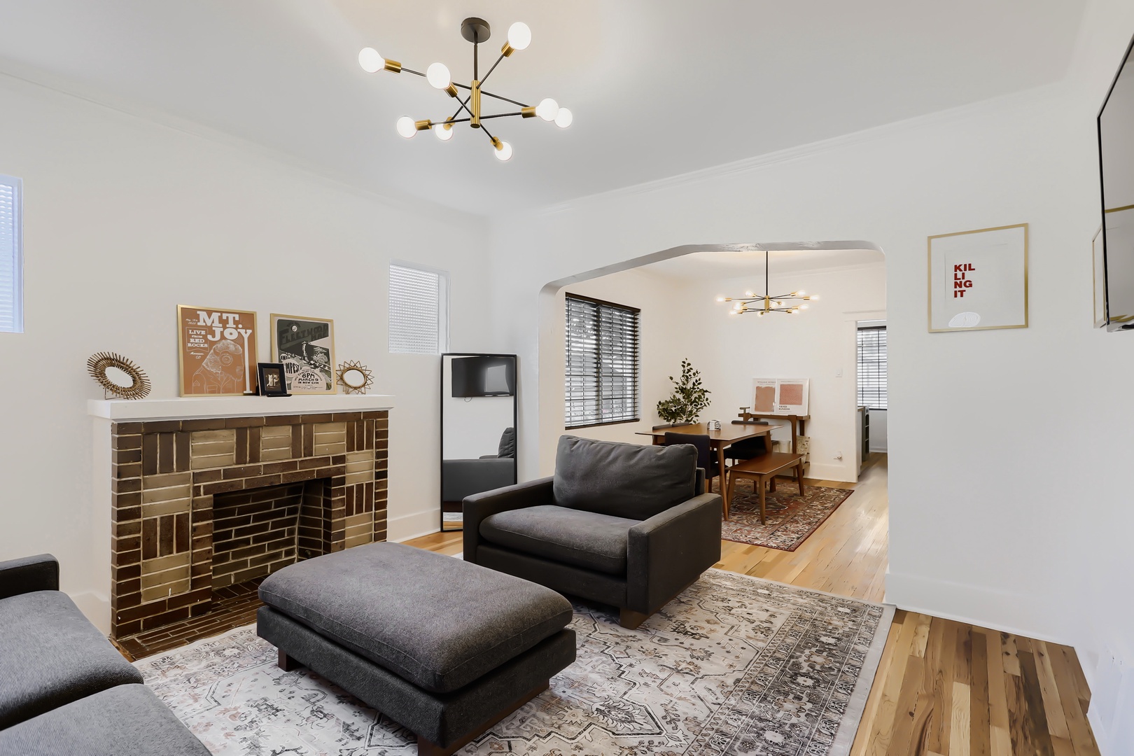 Step into your stylish retreat with bright modern spaces, warm wood floors, cozy seating, and thoughtful touches like the charming brick fireplace—all designed for your comfort and relaxation.