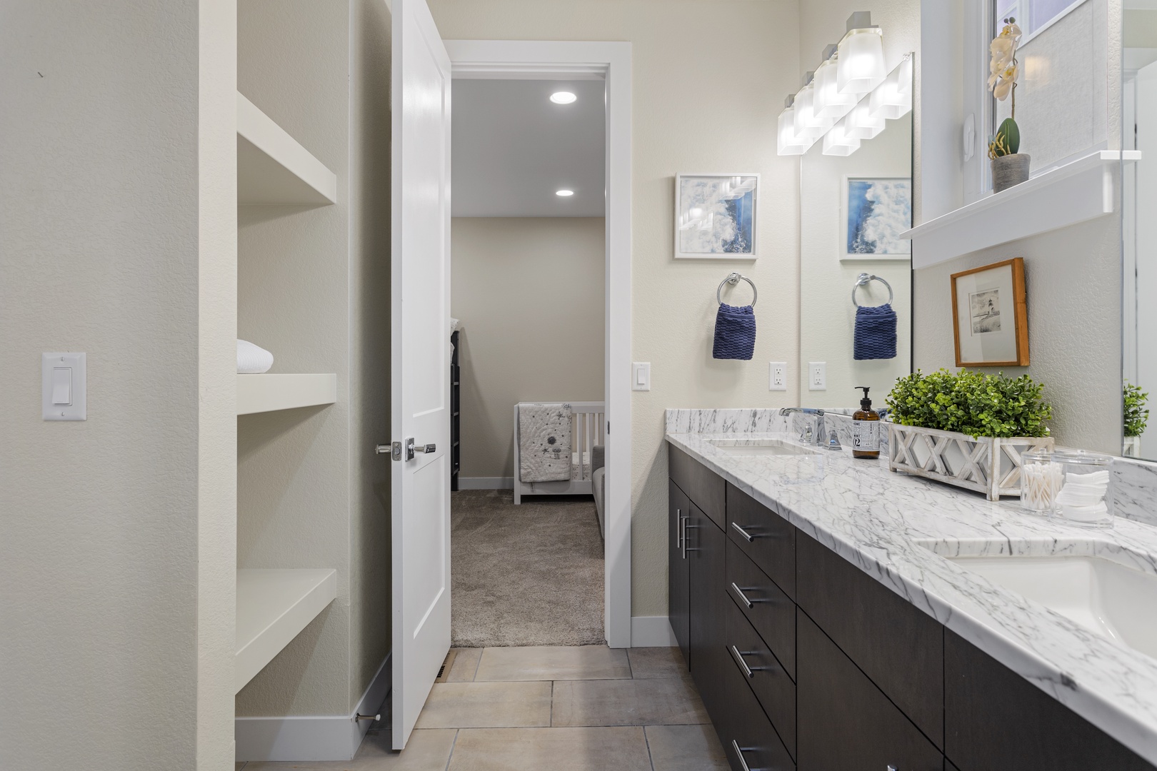 Refresh in your marble-topped bathroom featuring dual vanities, coastal-inspired décor, and a private toilet room for ultimate comfort.