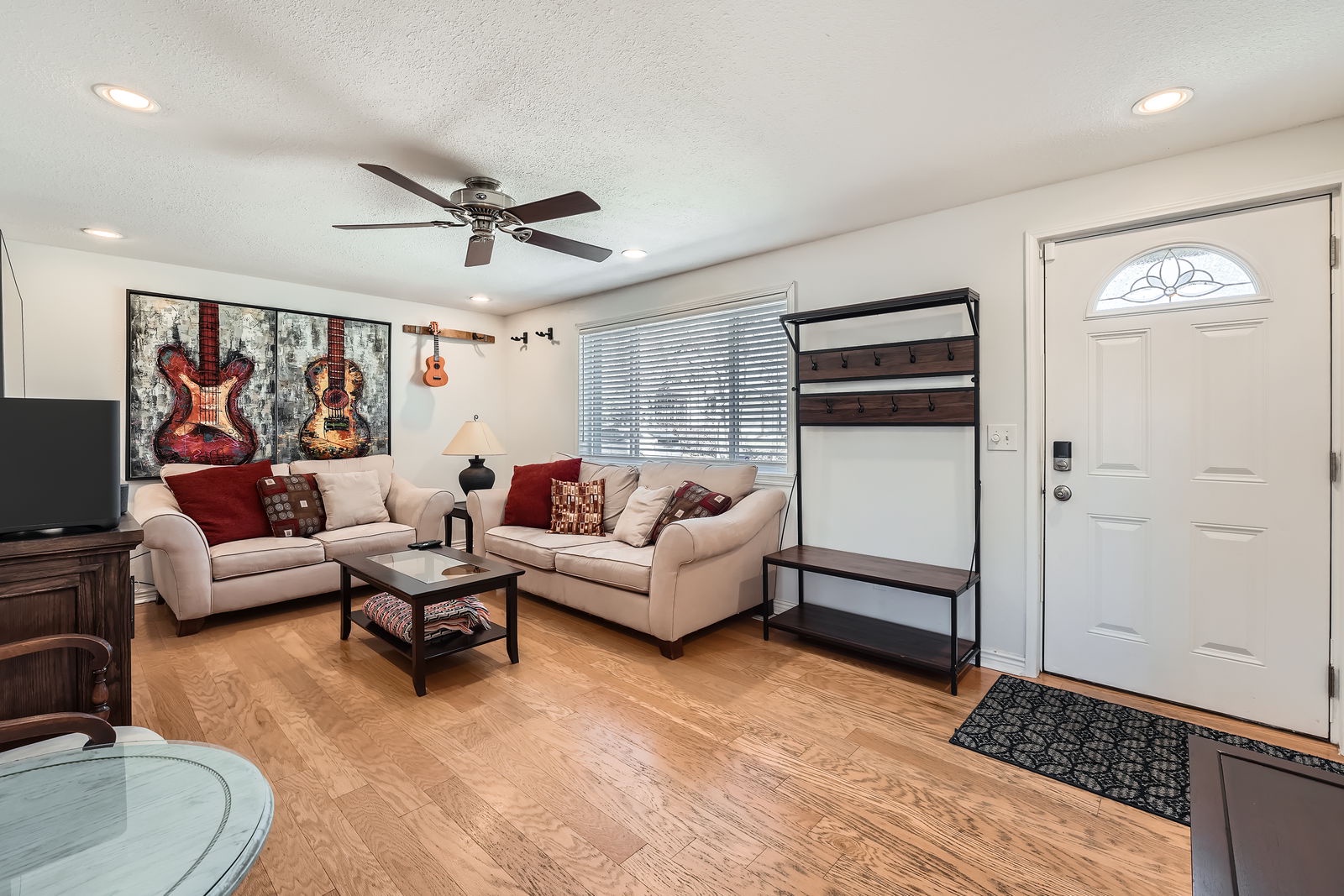 Unwind in your spacious living room featuring plush seating, music-themed artwork, and a convenient Murphy bed for extra guests.