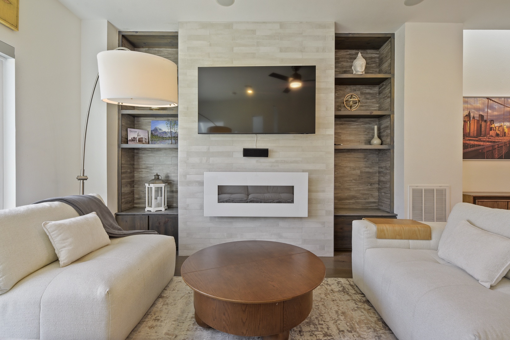 Sink into soft, plush seating in your living room, where a modern fireplace and built-in shelves create the perfect ambiance for cozy evenings together.