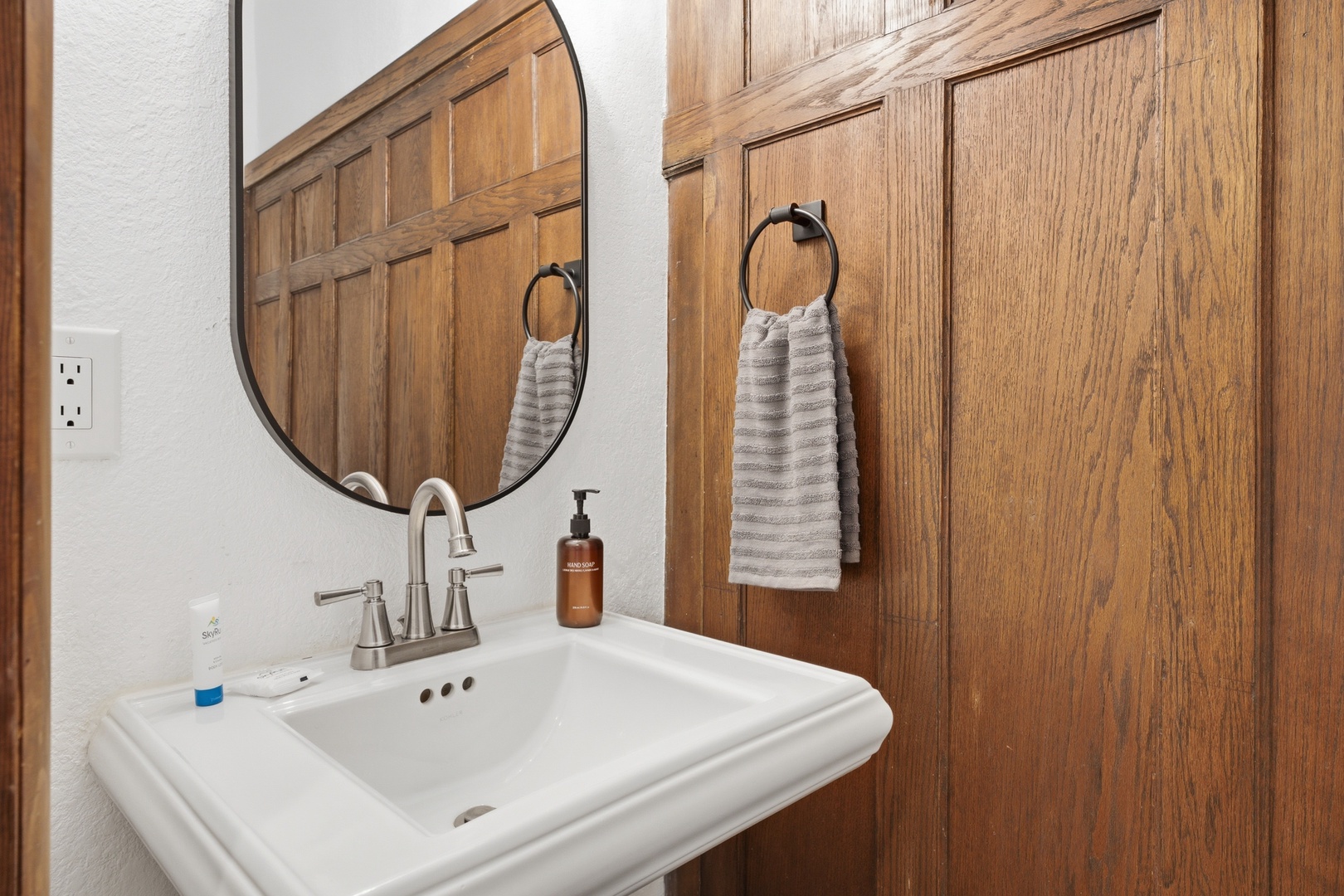 Freshen up in your private bathroom with soft towels, a pedestal sink, and warm wood accents that make every morning feel a little more luxurious.
