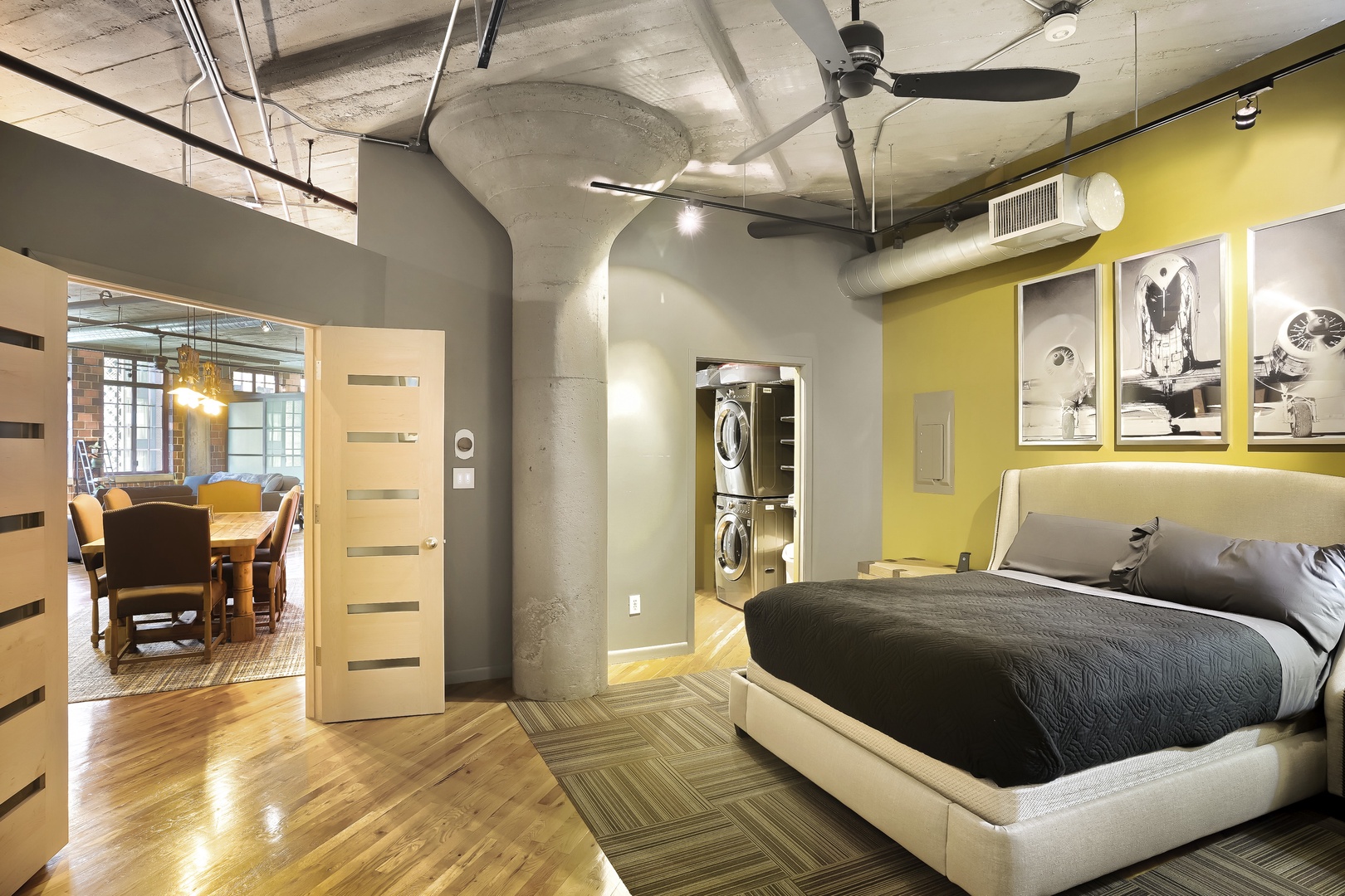 Unwind in your urban loft bedroom where modern industrial style meets comfort, complete with in-room laundry and an open layout connecting to your dining space.