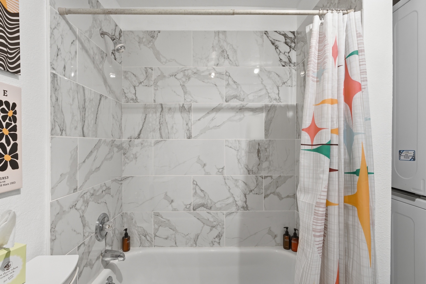 Step into this sleek marble-tiled bathroom, where modern elegance meets everyday comfort. Gleaming white surfaces and thoughtful details create your personal spa-like retreat after a day of exploring.