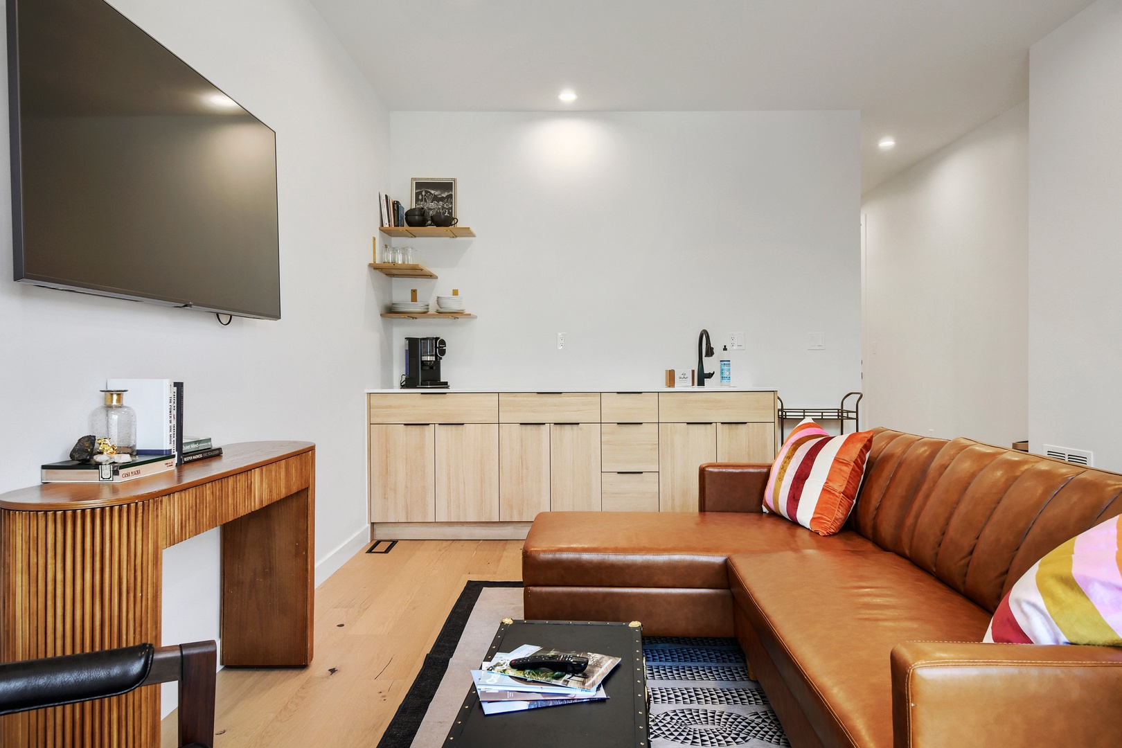 Relax on your stylish leather sectional in this bright, open living space with a fully equipped kitchenette and modern touches—perfect for unwinding after exploring the area.