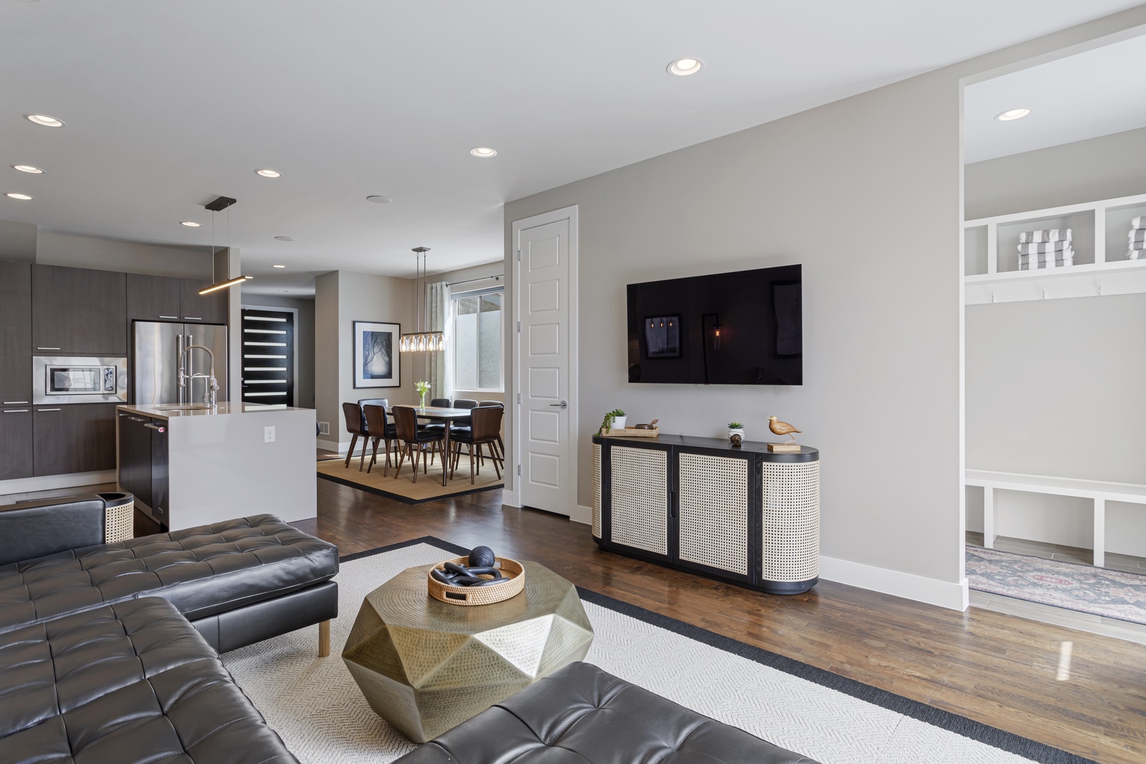 Relax in your spacious open-concept living area with sleek modern furnishings, gleaming hardwood floors, and stylish entertaining spaces.