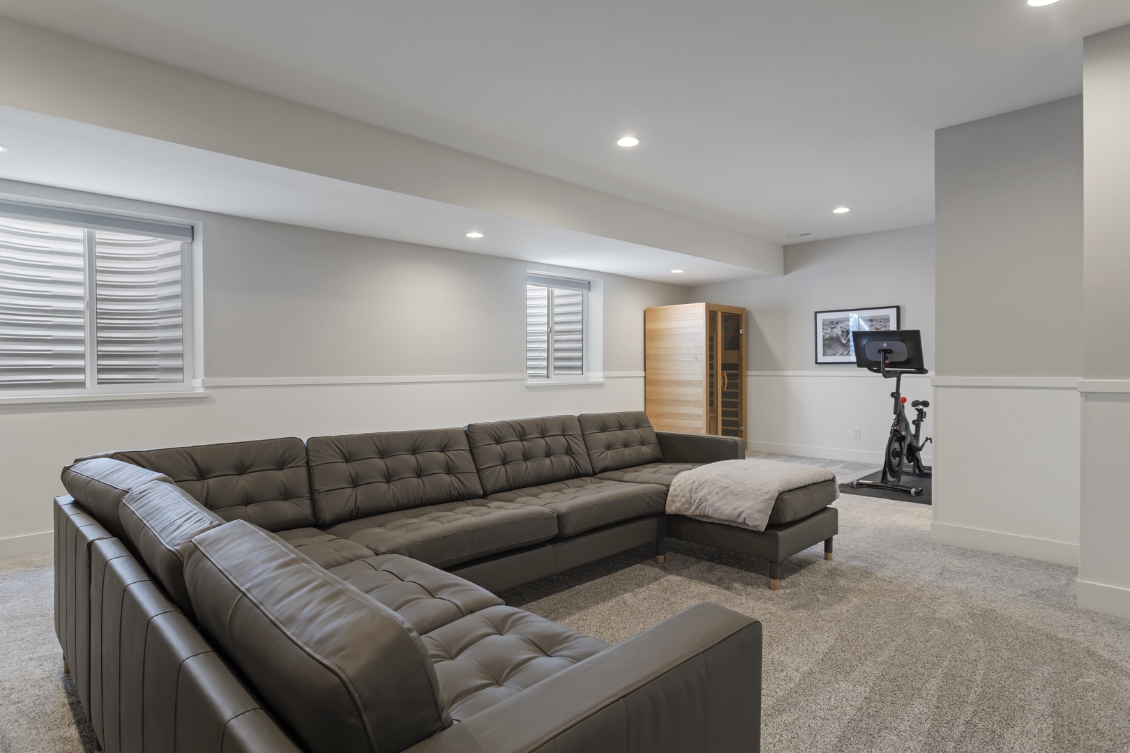 Unwind in your spacious basement retreat with plush sectional seating and modern entertainment setup.