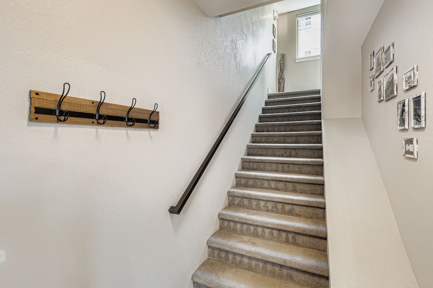 Bright, modern stairway with rustic touches—hang your coats on the wooden hooks and take in the light streaming from above as you arrive.