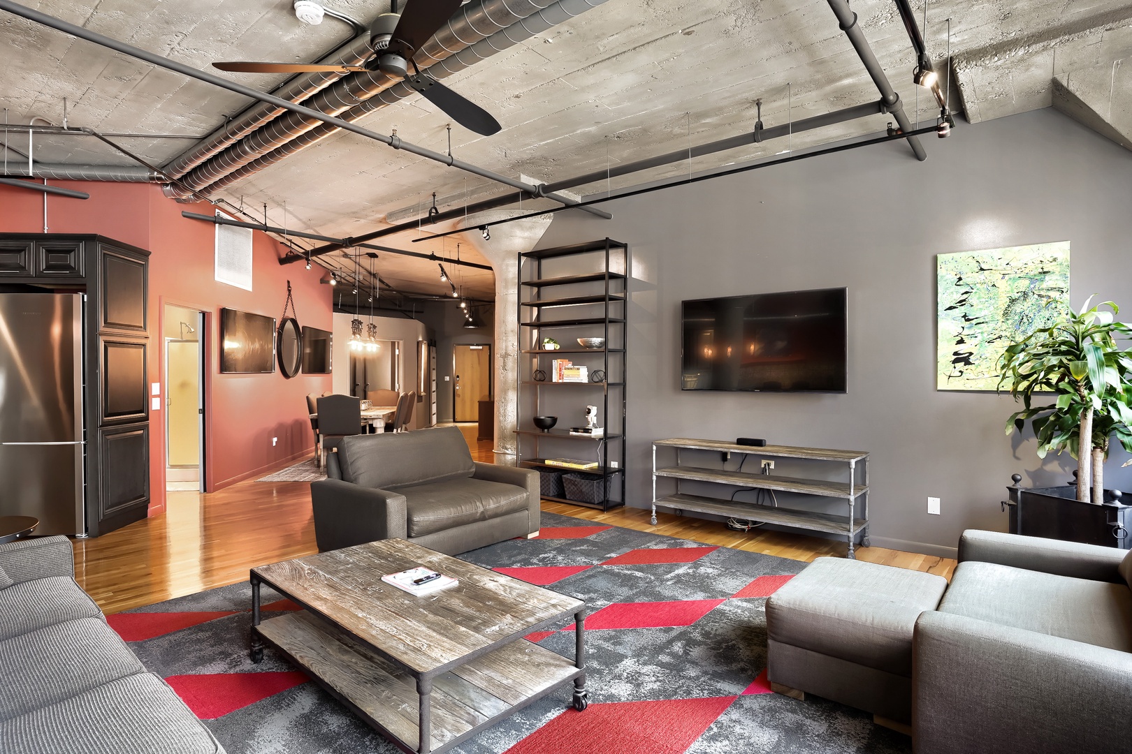 Unwind in your spacious loft with soaring concrete ceilings, sleek industrial touches, and a cozy seating area perfect for movie nights or simply relaxing after a day of exploring.