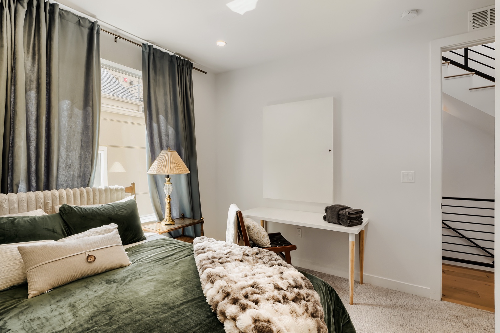 Unwind in your serene bedroom with elegant emerald tones, plush textures, and natural light filtering through soft drapes—your peaceful retreat awaits.