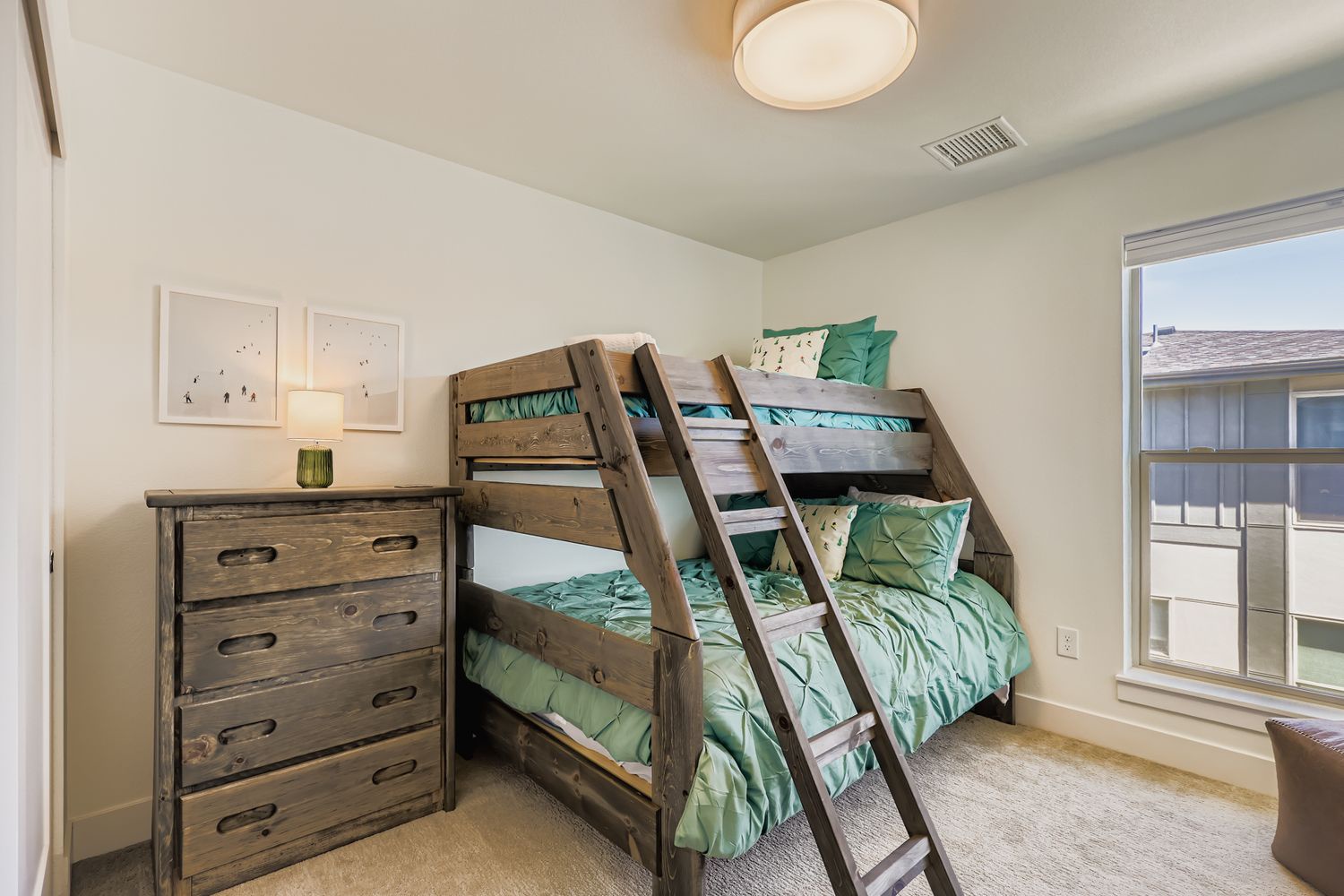 Rustic wooden bunks with cheerful green bedding create a cozy nest for your family. The bright space and thoughtful storage make settling in a breeze.
