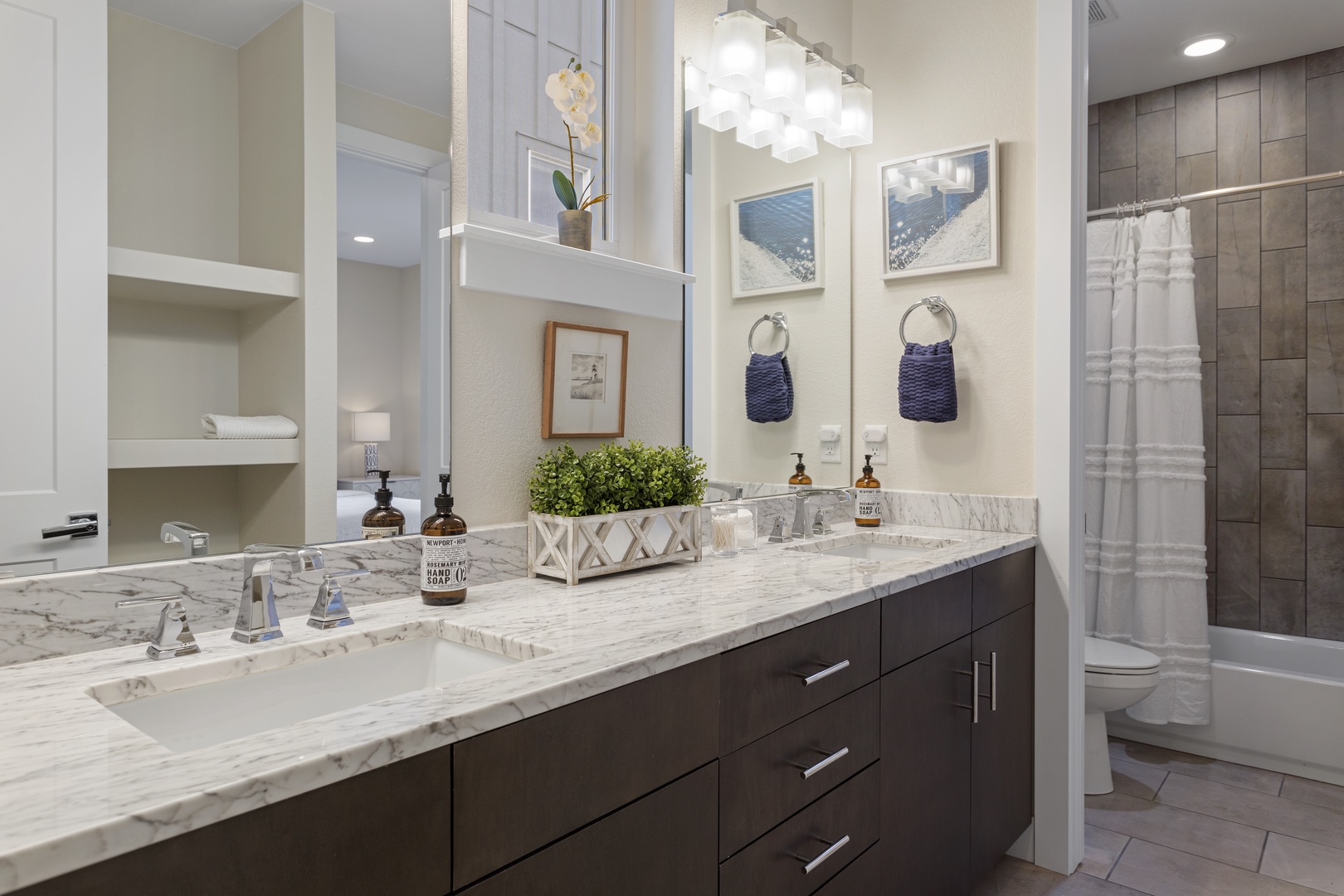 Step into your spa-like bathroom featuring elegant marble countertops, dual sinks, and thoughtful nautical touches that create a serene coastal retreat.