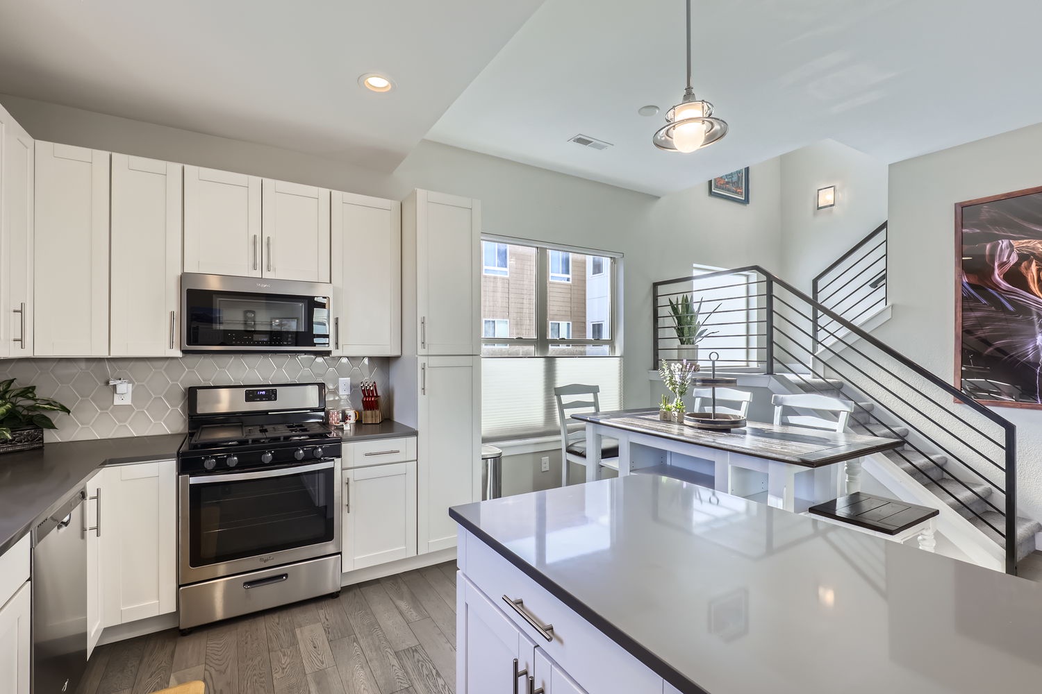 Bright, open kitchen with white cabinetry, stainless steel appliances, and plenty of counter space for your culinary adventures. Natural light fills the room, creating a welcoming atmosphere.