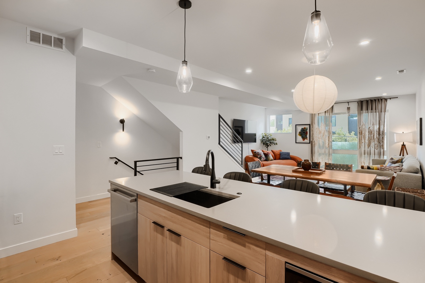 Step into your stylish open-concept space where the modern kitchen flows seamlessly into a sunlit dining and living area, perfect for gathering, cooking, and unwinding in comfort.