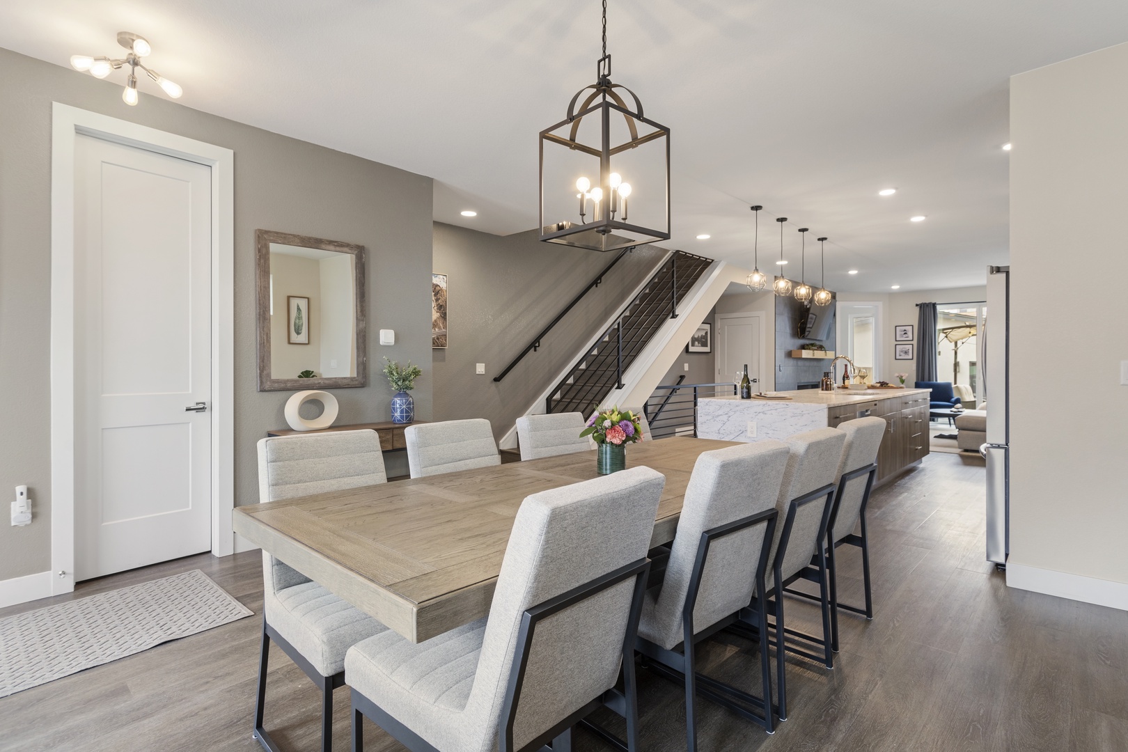 Gather around this spacious dining table where warm lighting and modern elegance create the perfect setting for memorable meals together.