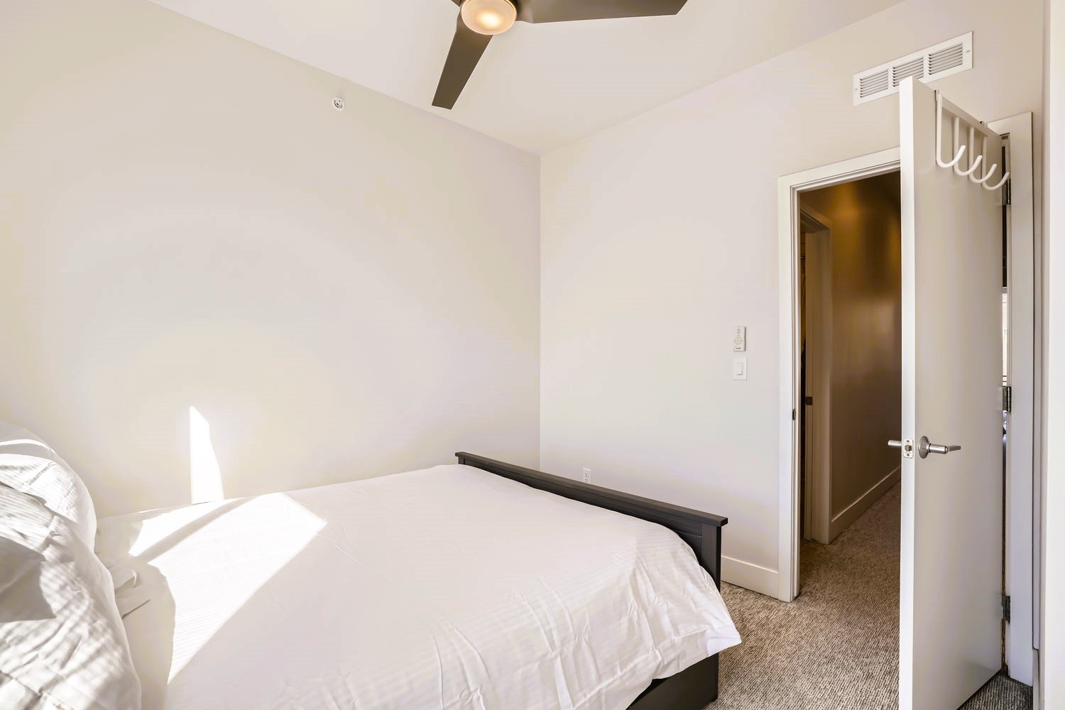 Drift into peaceful sleep in your bright, airy bedroom with plush bedding and modern ceiling fan keeping you comfortable.