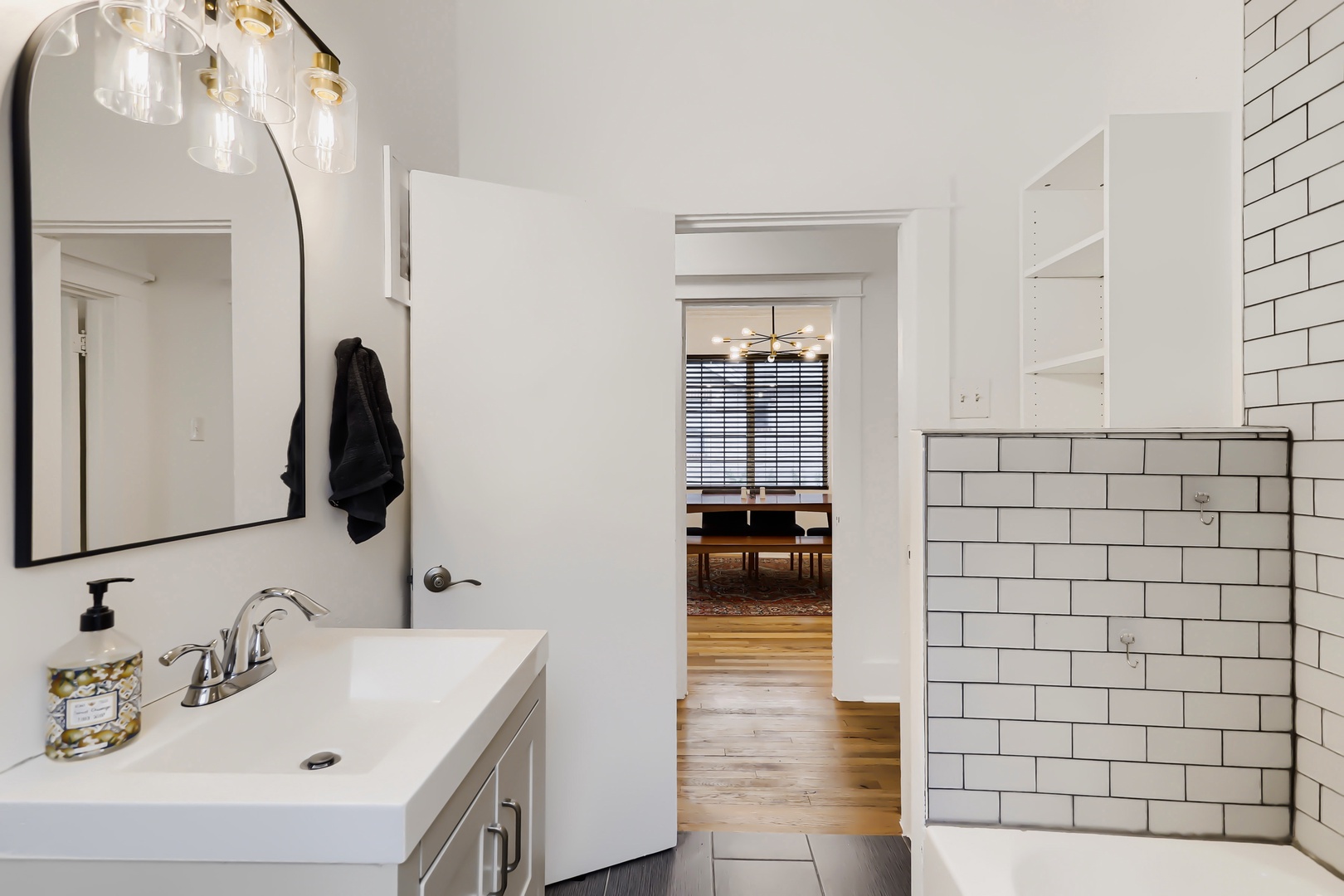 Your bright, modern bathroom awaits with clean subway tile, a spacious vanity, and warm wood floors flowing throughout. The thoughtful layout connects you seamlessly to the rest of the home.