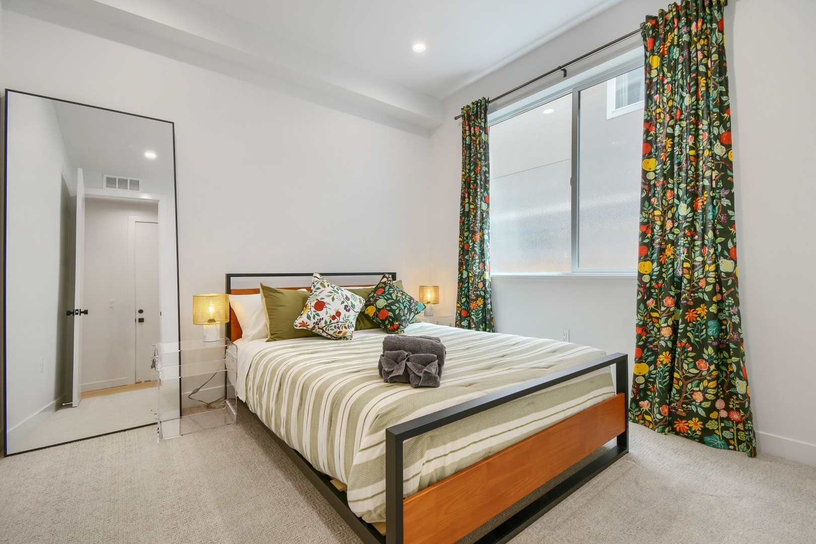 Serene bedroom retreat with vibrant botanical curtains, soft natural light, and a comfortable bed dressed with colorful pillows. Warm bedside lamps create the perfect ambiance for restful nights.