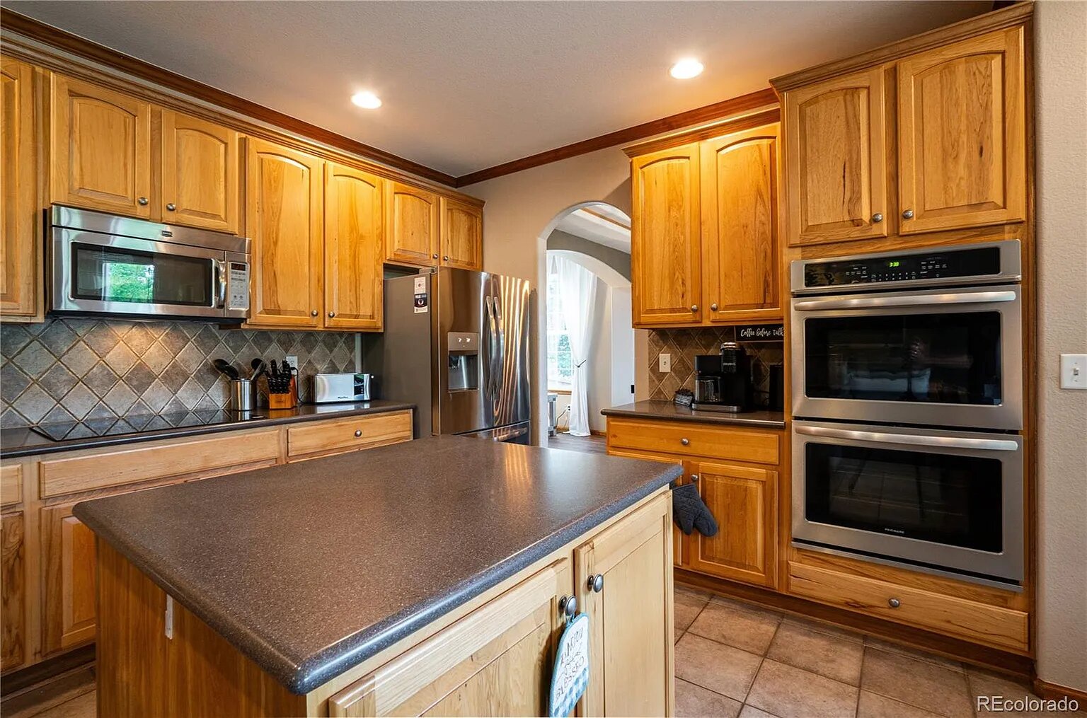 Your spacious kitchen features rich wood cabinets, granite counters, and premium stainless appliances perfect for preparing memorable meals.