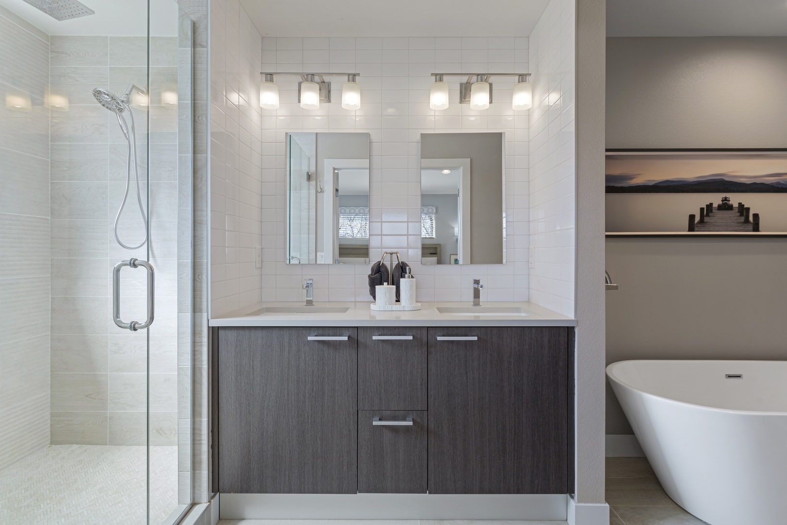 Indulge in your own spa-like sanctuary with dual vanities, a sleek soaking tub, and a spacious glass shower.