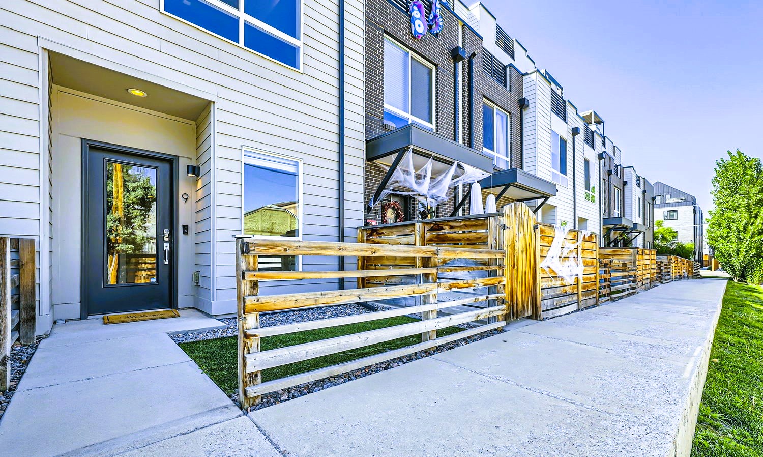 Modern townhome complex featuring contemporary architecture with private patios and sleek entrance design in a well-maintained neighborhood setting.