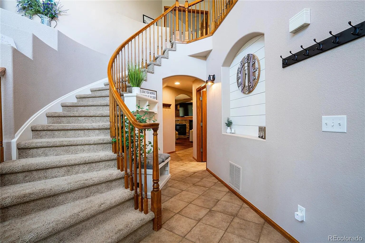 You'll love this welcoming entrance with its graceful curved staircase and warm lighting creating an inviting first impression of your home away from home.