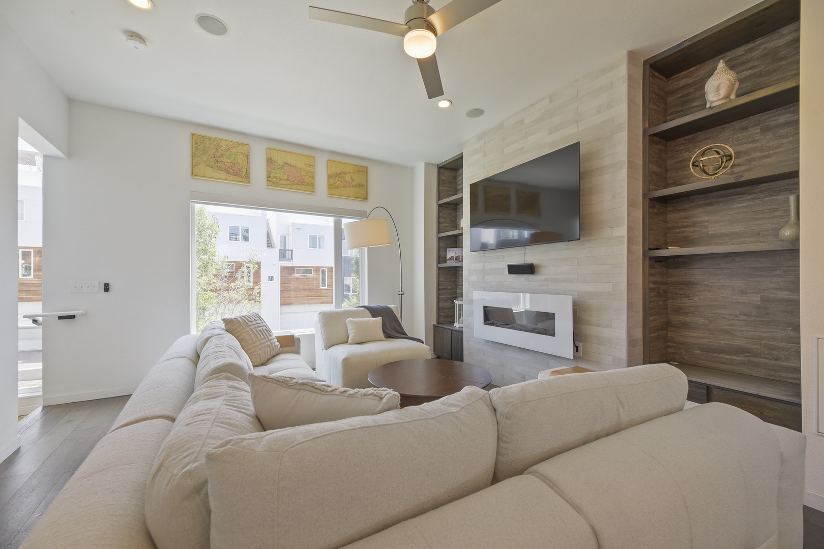 Unwind on plush sofas in your bright living room, where natural light pours through large windows and a modern fireplace adds warmth to your stay.