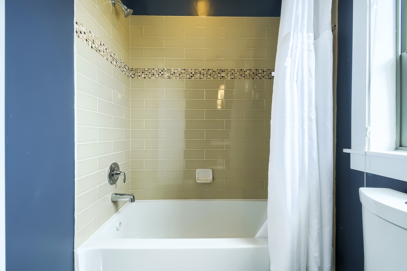 Soak away your worries in this immaculate tub after a day of exploring. The elegant tile work and soft shower curtain create a relaxing sanctuary just for you.