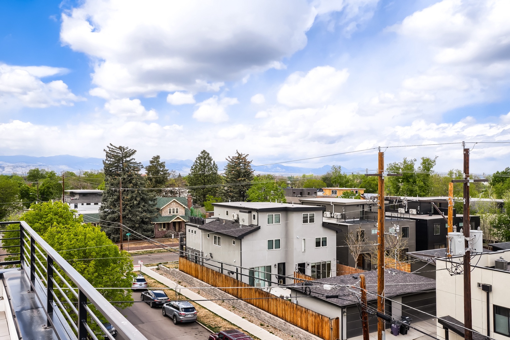 The property is situated in a residential neighborhood with tree-lined streets and mountain vistas in the distance, offering a peaceful suburban setting.
