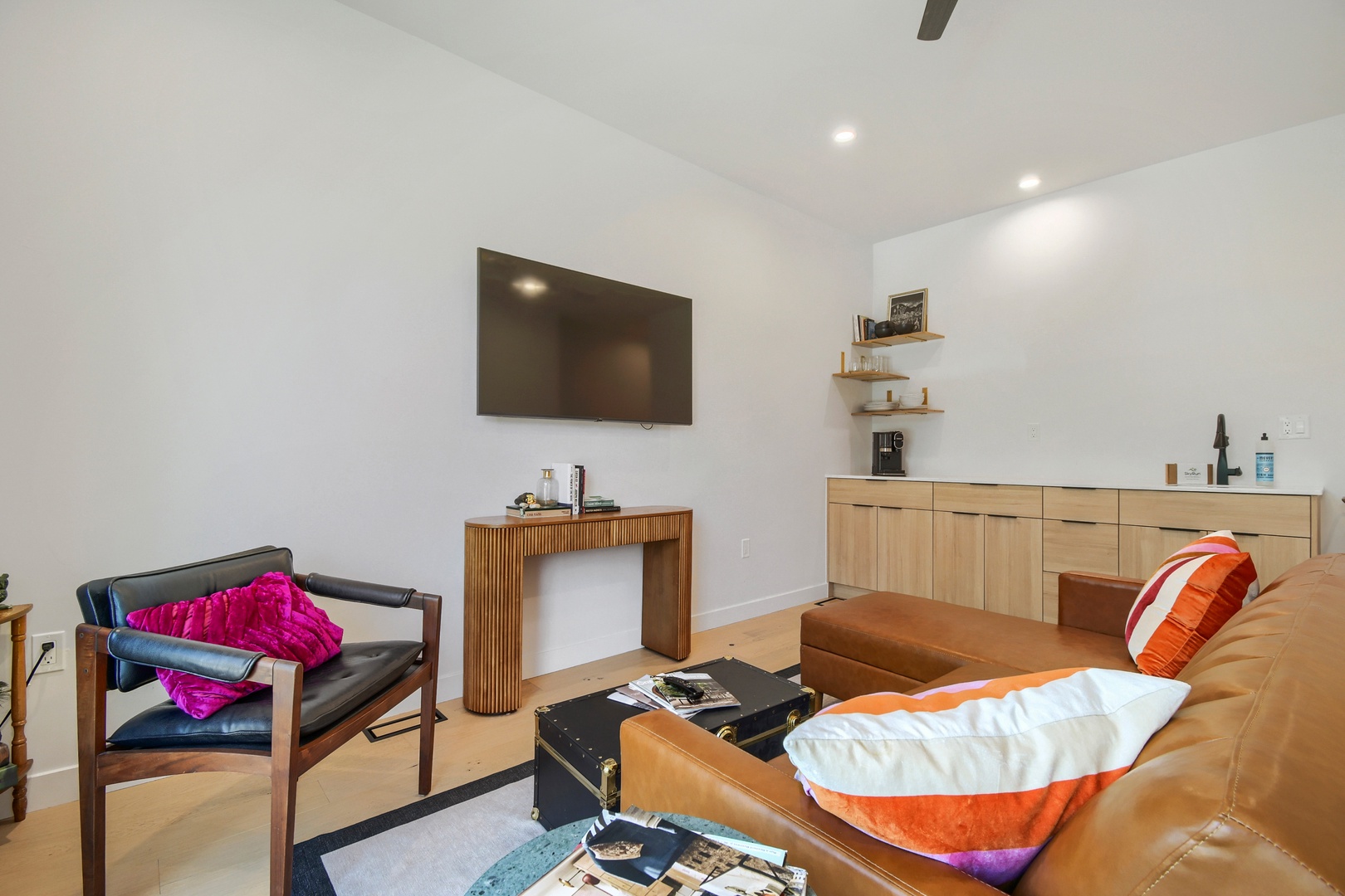 Sink into the plush leather sofa and unwind in your stylish living space, complete with modern furnishings and a cozy, minimalist vibe that instantly helps you relax.