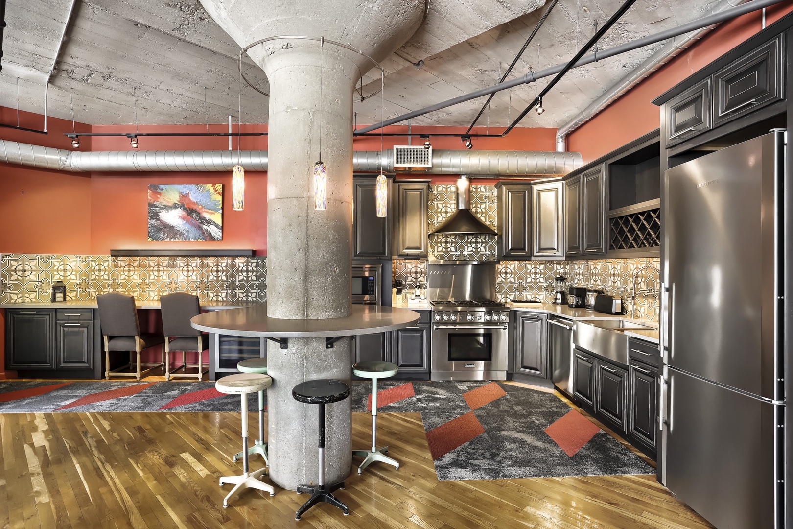 Your stylish industrial loft kitchen awaits—gleaming stainless appliances, custom cabinetry, and a unique concrete column with built-in seating make cooking and gathering effortlessly cool.